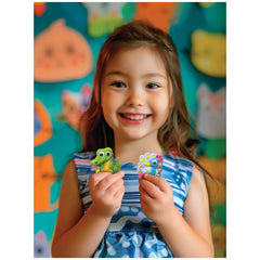 4M Mould & Paint Googly Eyes Animals kit showcased by a smiling girl in a blue dress against a colorful wall, holding green t