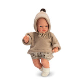 Koke doll in beige hooded sweatshirt and floral shorts, featuring a soft, huggable body and clear eyes.