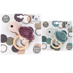 ARTESAVI Turtle Plush Rattle in purple and blue, with wooden ring handle, designed for infants 0+ months.