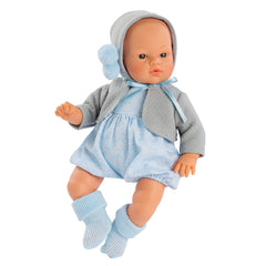 Koke Ranita doll wearing a gray knitted jacket and blue outfit, with a bald head and clear eyes.