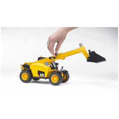Yellow Bruder CAT telehandler toy with extendable arm and realistic features, adjusted by a hand.