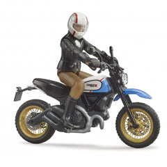 Toy figure riding a blue and black Bruder Scrambler Ducati Desert Sled with gold wheels and detailed features.