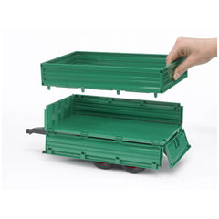 Green Bruder tandemaxle trailer with removable top section being lifted by a hand, showcasing three side gates.