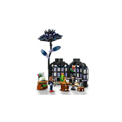 LEGO Black Dahlia Flower set features a striking black dahlia atop a mini conservatory with windows. Two figures interact near desks and a stool, set among vibrant plant elements.