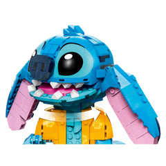 LEGO® Stitch construction set features a vibrant blue character with a playful expression, large round eyes, and movable ears. Dressed in a yellow Hawaiian shirt, Stitch's pink-lined ears and friendly smile add charm to this engaging toy, perfect for young builders and Disney fans.