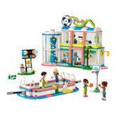 Colorful LEGO® Friends Sports Center featuring four mini-dolls engaged in various sports. The building includes a basketball hoop, soccer goals, and a tennis area, surrounded by vibrant accessories and a slide.