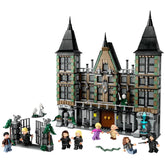LEGO Harry Potter Malfoy Manor construction set featuring a detailed model of the mansion with pointed towers and iconic architectural elements. The scene includes six minifigures: Draco Malfoy, Harry Potter, Bellatrix Lestrange, Hermione Granger, and more, positioned around the set with a decorative gate and magical accessories.