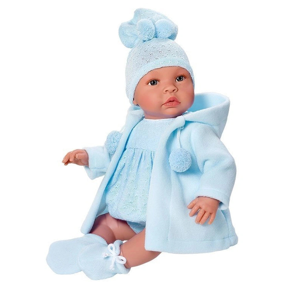 Leo doll wearing a cozy blue duffle coat, matching romper, booties, and a hat with pom-poms, sitting upright.
