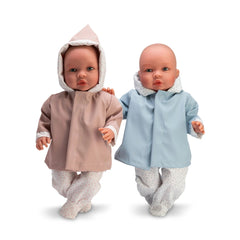 Two ASI Dolls with raincoats, one in pink, the other in blue, both wearing matching patterned outfits and hoods.