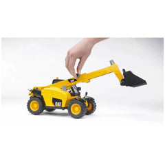 Yellow Bruder CAT telehandler toy with extendable arm and realistic features, adjusted by a hand.
