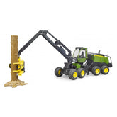 Bruder John Deere 1270G Harvester toy, green and yellow, with articulated arm grasping a tree trunk.