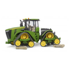 Green John Deere 9620RX toy tractor with yellow track belts, detailed cabin, on white background.