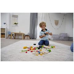 Eichhorn Constructor Accessories construction set with a young boy playing on a shaggy white rug beside a wooden table.
