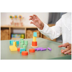 Eichhorn Staple Game features colorful sorting and stacking toys on a green table, promoting playful learning for children.