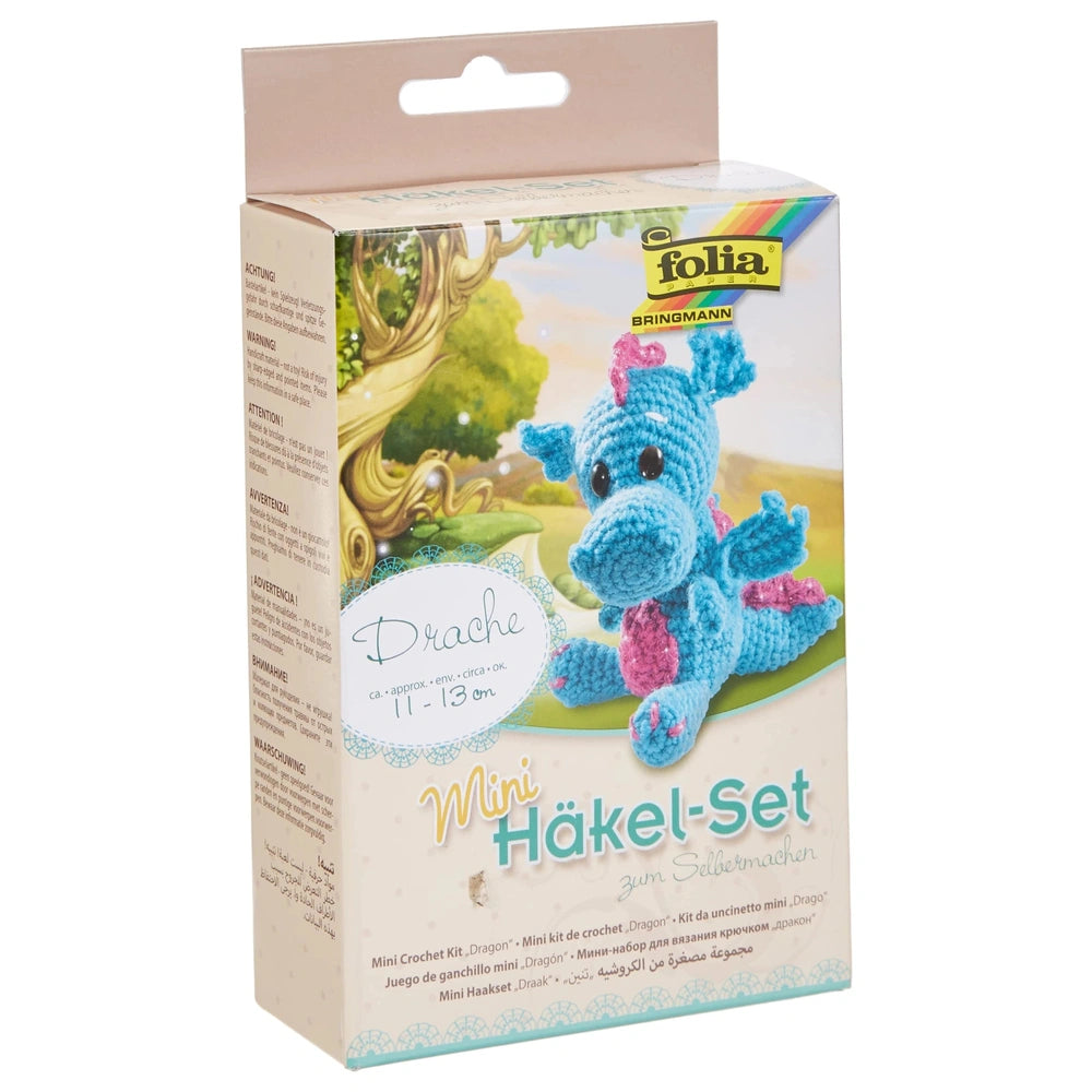 Folia Mini Crochet Kit featuring a blue dragon, colorful landscape illustration, and clear plastic window on beige cardboard.