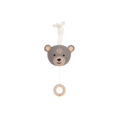 Brown knitted teddy bear hanging from a wooden ring by a string, featuring a lighter face, paws, and black eyes.