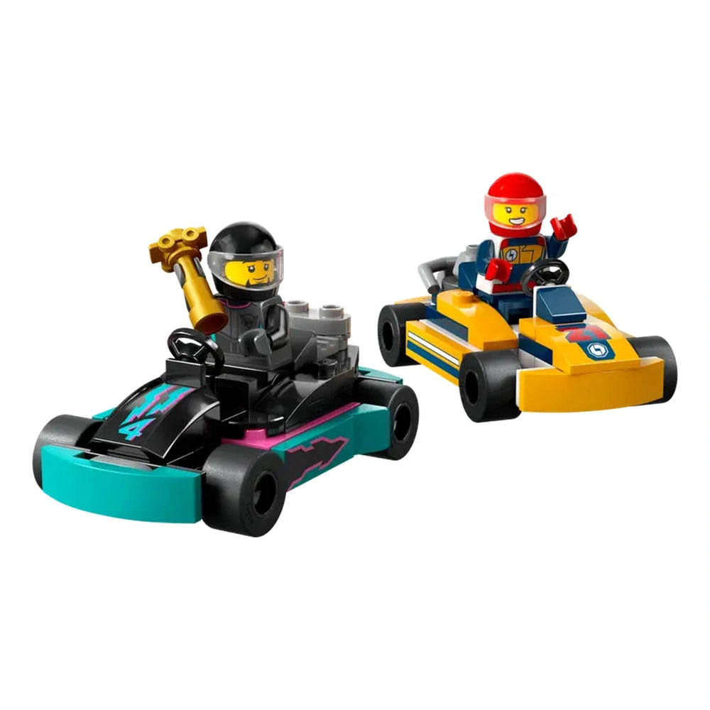 Two colorful LEGO® go-karts, one turquoise with black and pink accents, and a yellow one with blue details. Each kart has a driver minifigure, one holding a trophy. Perfect for imaginative racing adventures.