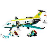 LEGO City Emergency Air Ambulance Plane in vibrant colors, featuring a twin-engine design, fold-down stairs, and minifigures of a pilot, doctor, and paramedic rescuing a skier on a stretcher. A toy snow scooter is nearby, along with an airport scene displaying a wind sock.
