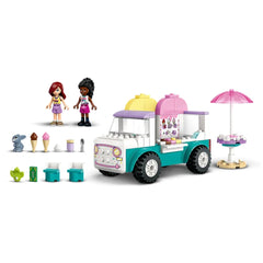Two LEGO® Friends minidolls stand beside a vibrant ice cream truck, featuring colorful cones, a bunny figure, and play accessories.