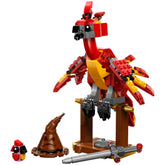 Highly posable LEGO® Fawkes™ figure stands on a buildable stand, featuring vibrant red and yellow colors with movable wings, a head, and beak. A small baby Fawkes figure and iconic accessories like the Sword of Gryffindor™ and the Sorting Hat™ are included.