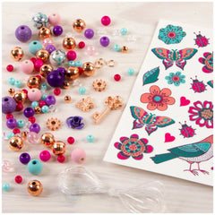 Bedazzled charm bracelet kit featuring colorful, glossy plastic beads and butterfly stickers scattered on a white surface.