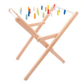 New Classic Toys drying rack features a light brown wooden frame with colorful plastic clothes pins in various shades.