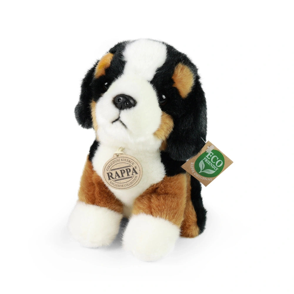 Plush mountain dog toy in brown, white, and black, featuring an eco-friendly label and soft texture against a light backgroun