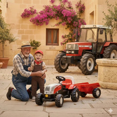 Rolly Toys Rollykid Steyr 6165 Cvt Tractor with trailer is parked outdoors beside a man and child, surrounded by potted plant