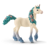 Blossom Unicorn Foal figurine in white with blue and pink mane and hooves, standing on a smooth white surface.