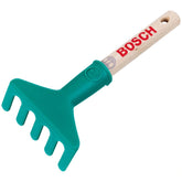 Theo Klein Bosch Garten hand rake with a brown wooden handle and green plastic head, featuring logo and holes for hanging.