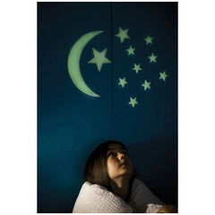 4M Glow in the Dark Moon & Stars furniture with a person in white against a blue wall featuring a crescent moon and five star
