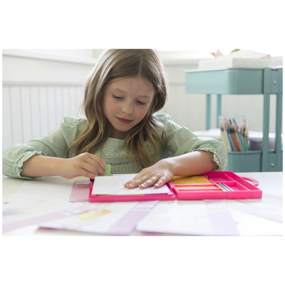 KidzMaker My Design Portfolio Fashion Studio features a girl with blonde hair in a light green shirt holding a pink book at a