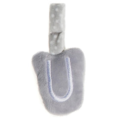 Grey plush letter "U" with white polka dots on a soft beige strap, ideal for children's playrooms.