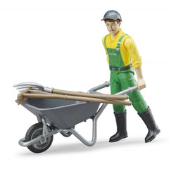 Farmer figure with yellow shirt, green overalls, black boots, holding a wheelbarrow with pitchfork and besom.