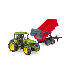 Green toy John Deere tractor with a red tipping trailer attached, on a white background.
