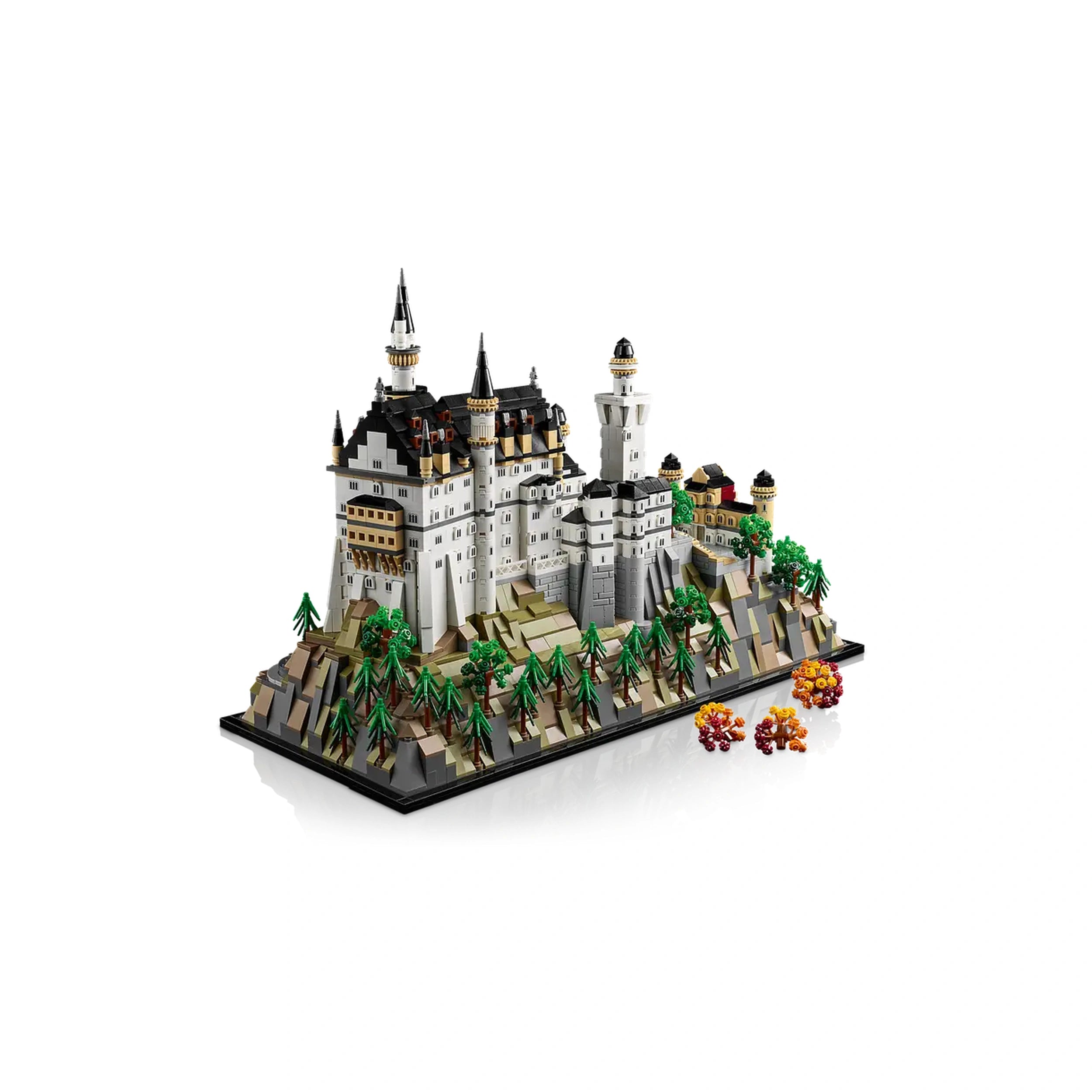 LEGO Architecture model of Neuschwanstein Castle featuring intricate details, tall spires, and surrounding green trees on a scenic base.