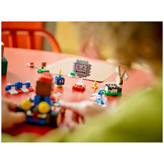 Colorful LEGO Mario Kart playset featuring a variety of bricks, racetrack elements, and characters like LEGO Mario, a Thwomp, and a Bob-omb arranged on a red table. A child's hands are focused on building a kart, surrounded by fun obstacles and features, including a banana and checkered flags, in an engaging, imaginative setup.