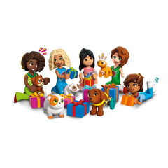 Five LEGO Friends characters, each holding or surrounded by colorful presents, with a variety of playful pets nearby.
