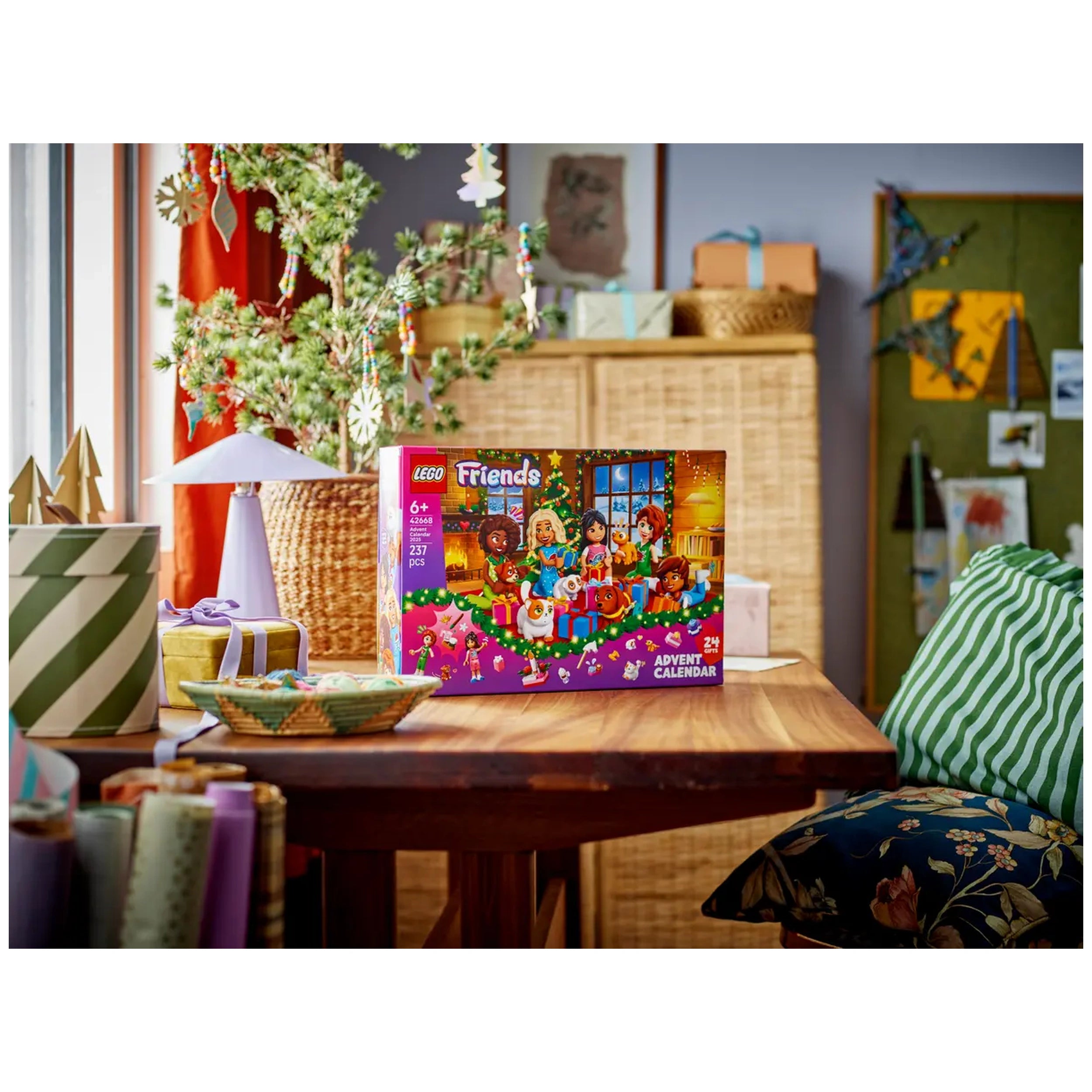 LEGO® Friends Advent Calendar 2025 displayed on a wooden table surrounded by festive decorations, featuring five cheerful minidolls and fun animal figures.