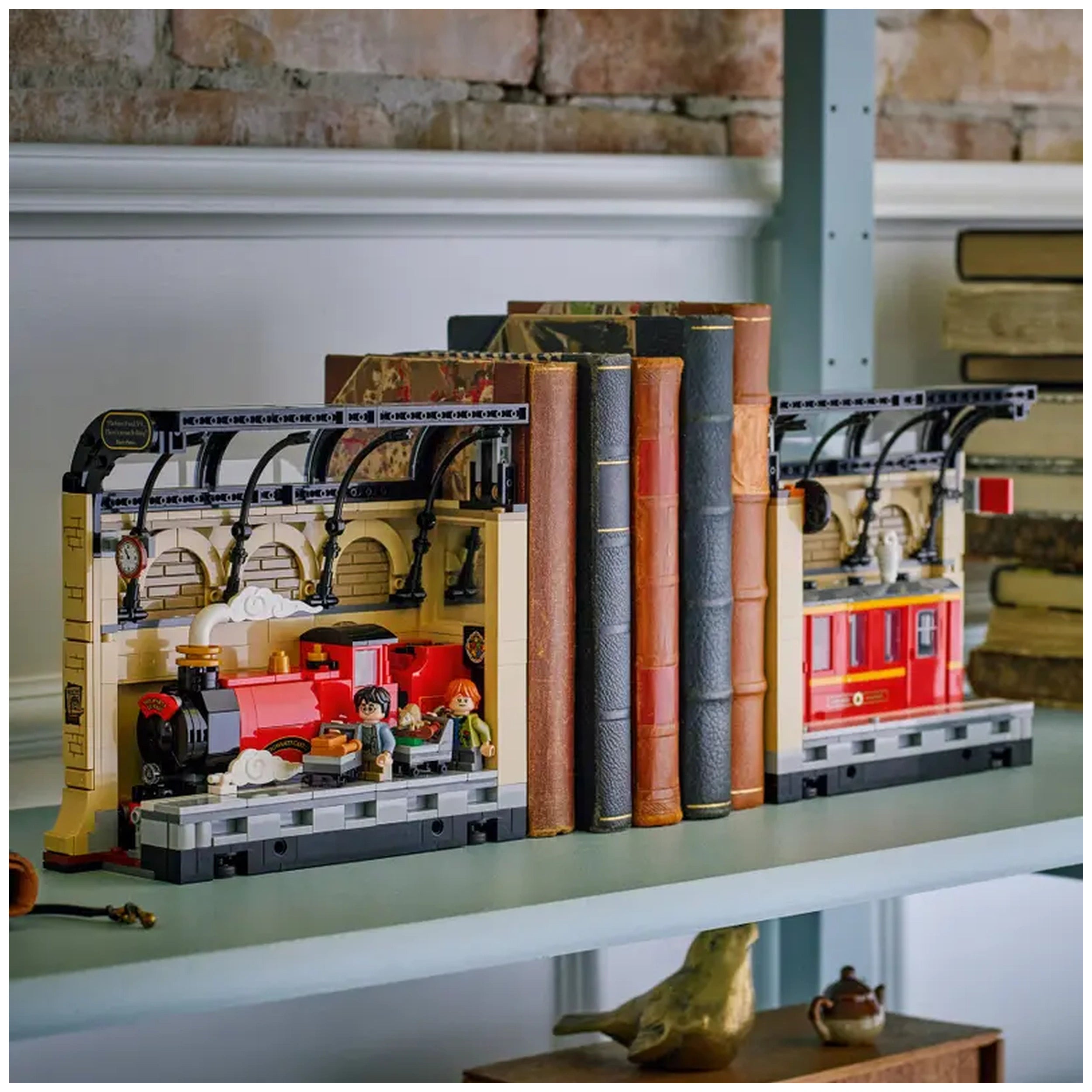 LEGO Harry Potter Book Nook featuring the Hogwarts Express, with Harry and Ron minifigures, surrounded by colorful books on a shelf.