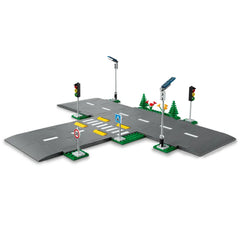 LEGO® City Road Plates construction set featuring a detailed intersection with traffic lights, road signs, and green trees.