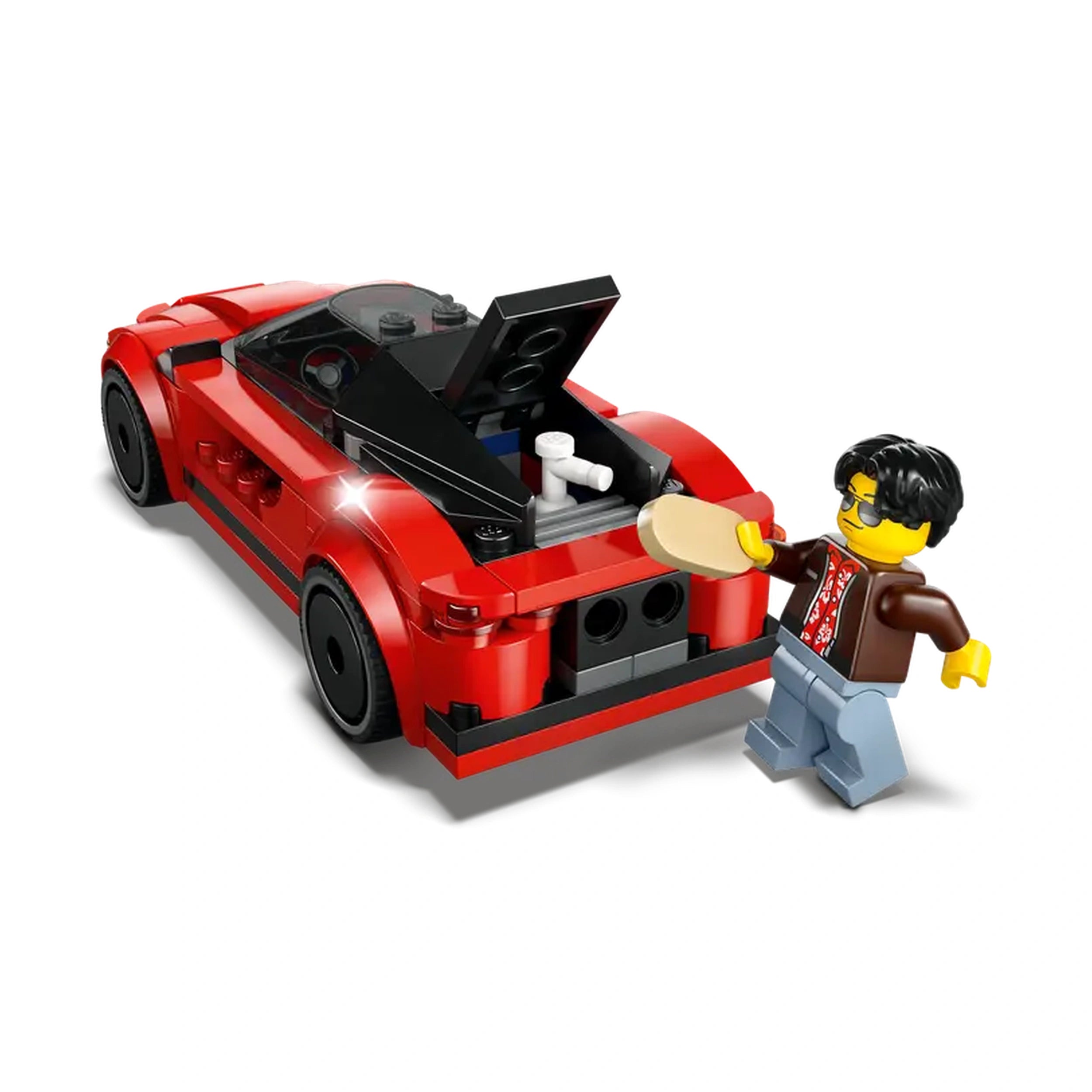 A bright red Lego sports car with a raised trunk stands alongside a Lego minifigure wearing sunglasses and a patterned shirt, holding a toy cell phone.