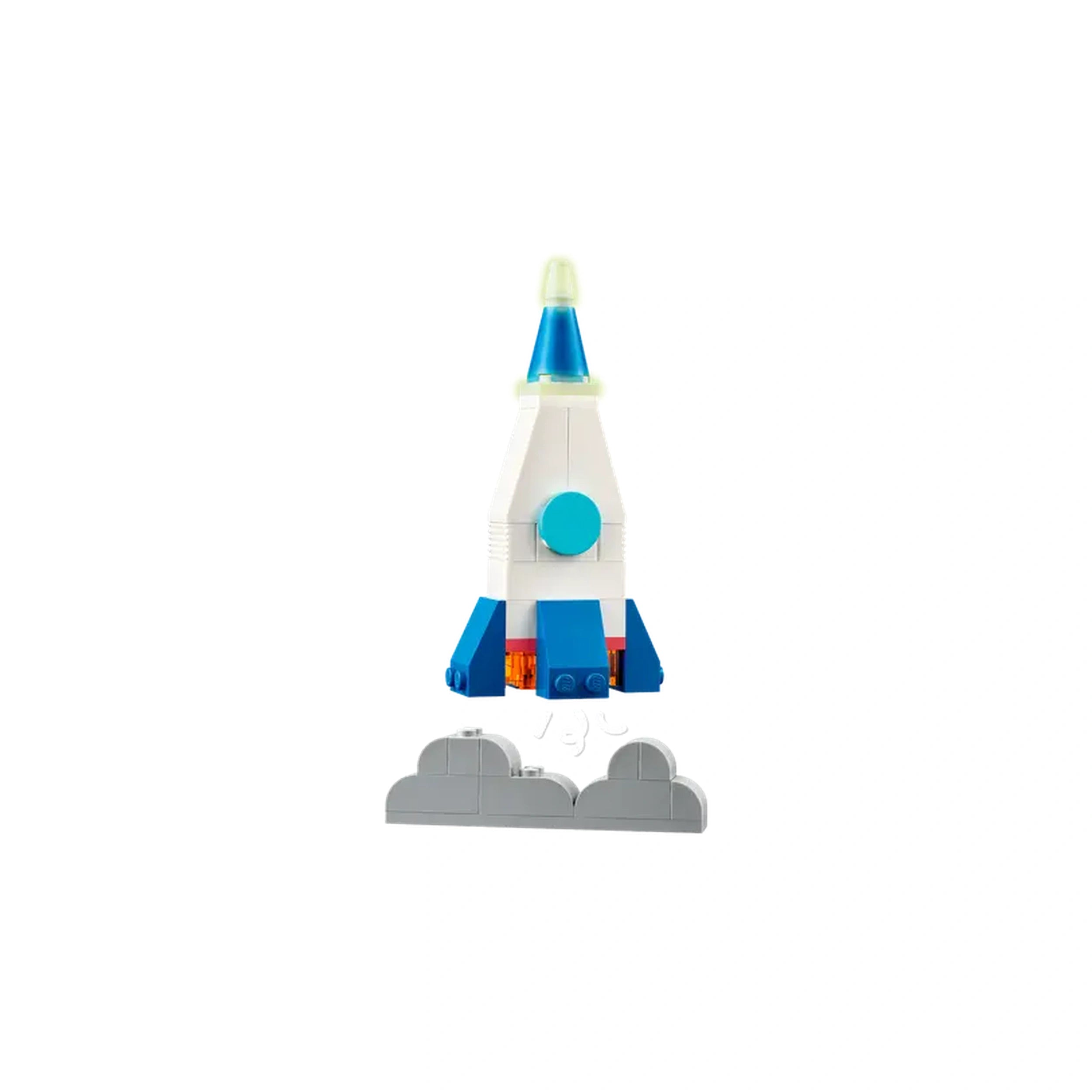 Colorful LEGO rocket ship with a blue tip, white body, and blue fins, soaring above gray cloud-shaped base pieces.