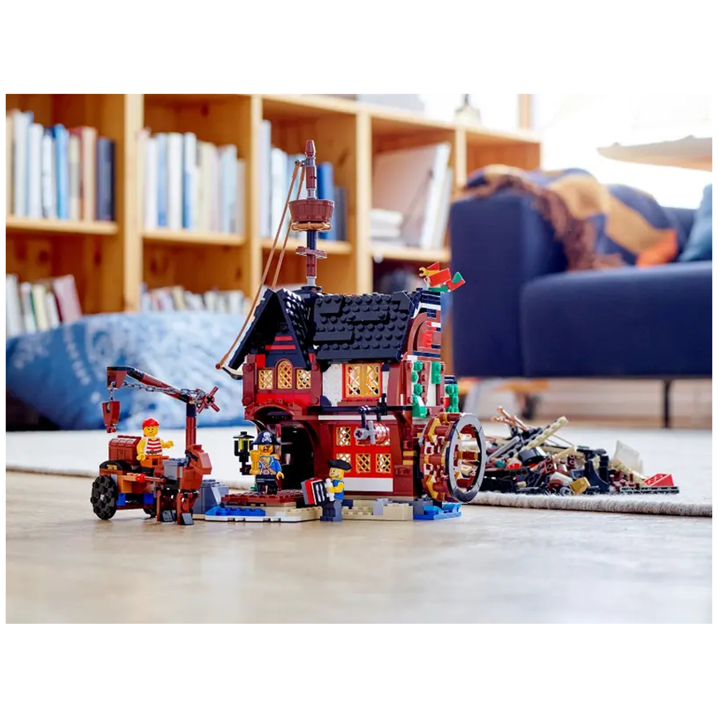 Colorful LEGO® Creator 3in1 Pirate Ship set displayed indoors, featuring intricate building details, minifigures, and pirate accessories on a wooden floor.