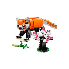 Colorful LEGO® Majestic Tiger model featuring an orange tiger with a bushy tail and articulated limbs, alongside a flowering tree with pink blossoms and a green stick.
