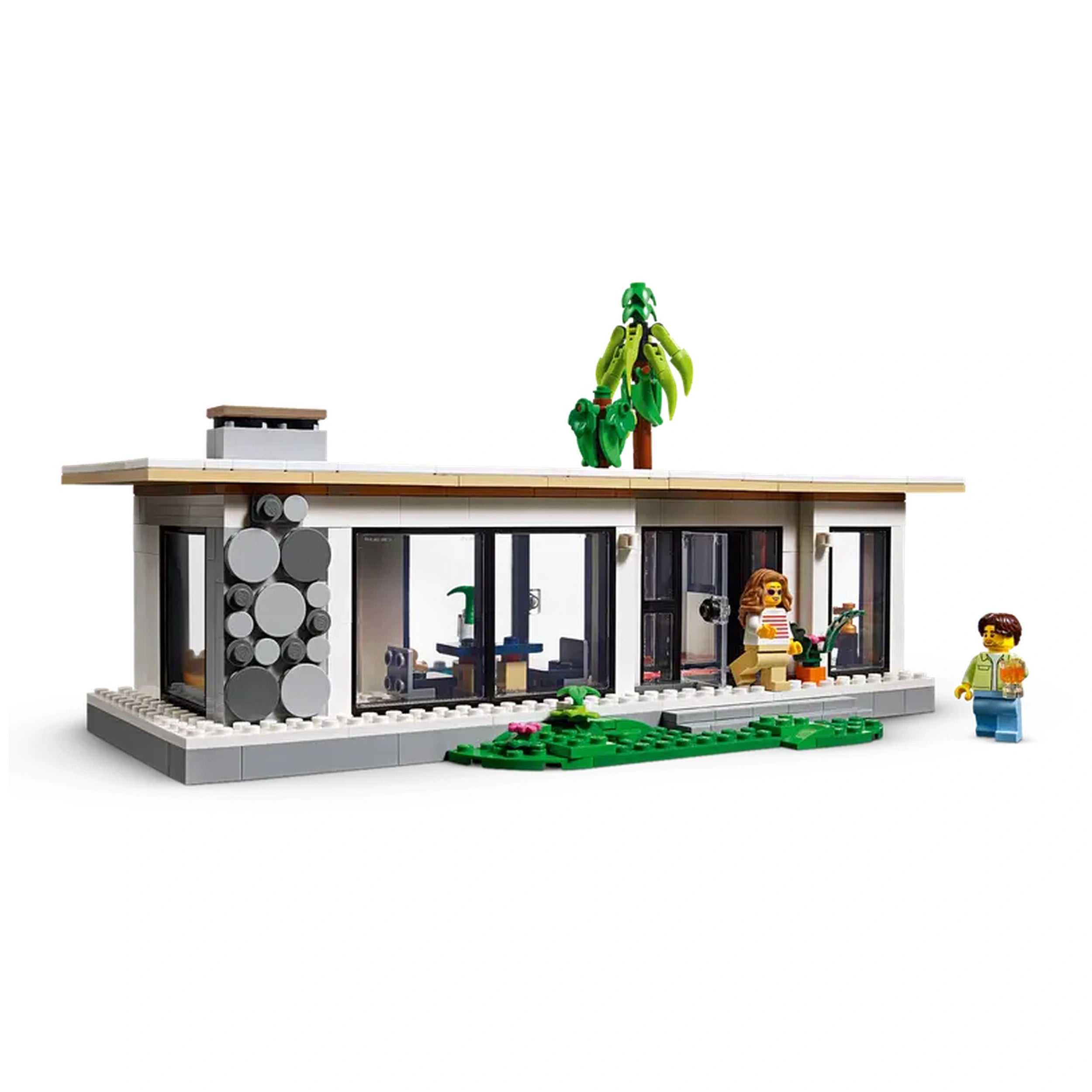 Modern LEGO Creator house set featuring large windows, a palm tree, and two mini-figures on a green lawn.