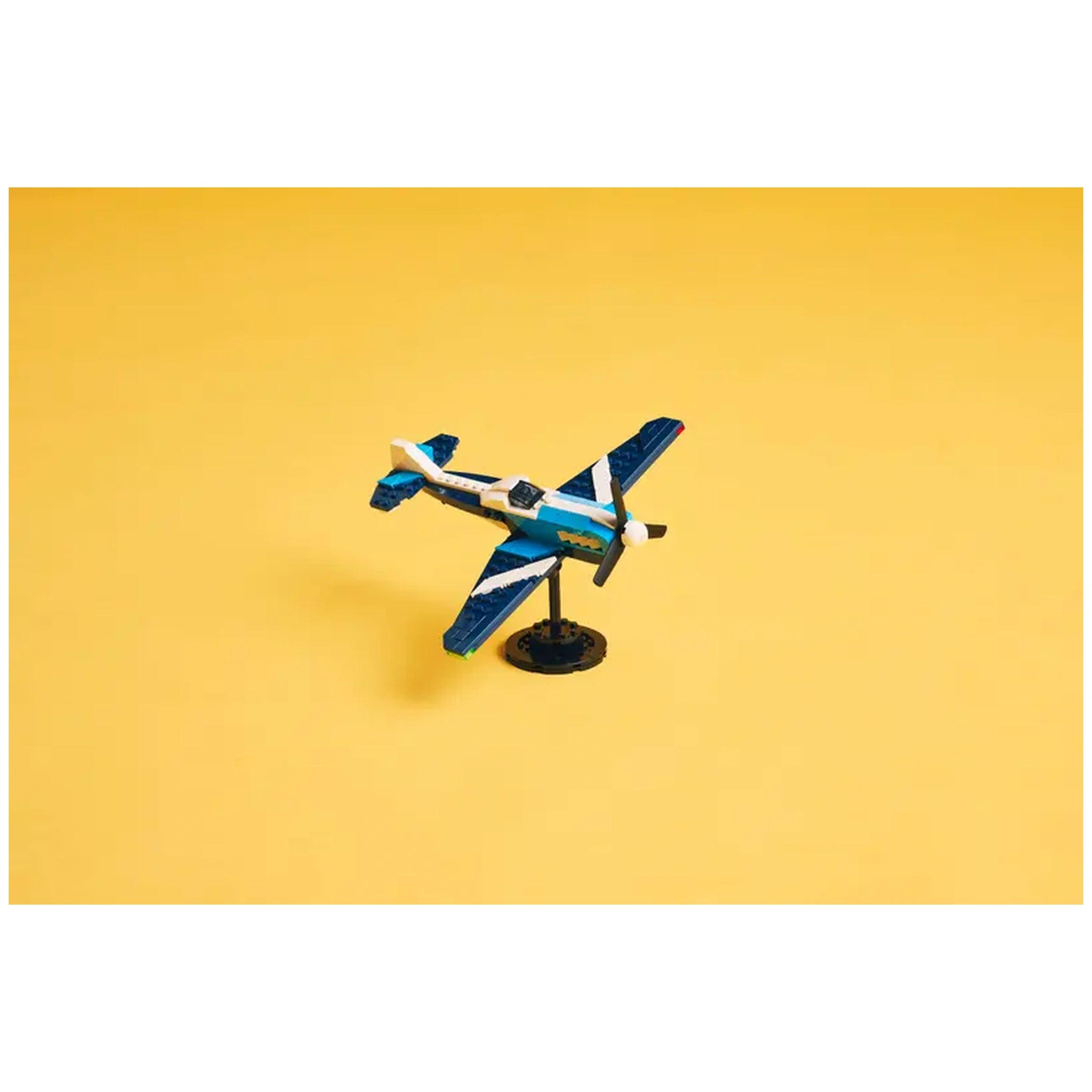 LEGO Creator Race Plane model featuring a blue and white design, displayed upright against a vibrant yellow background.