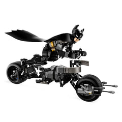 Batman, in a black costume with a flowing cape, rides the Bat-Pod bike. The figure is highly detailed and fully posable, showcasing dynamic action. The sleek bike features large black wheels and two stud launchers, emphasizing a high-tech design.