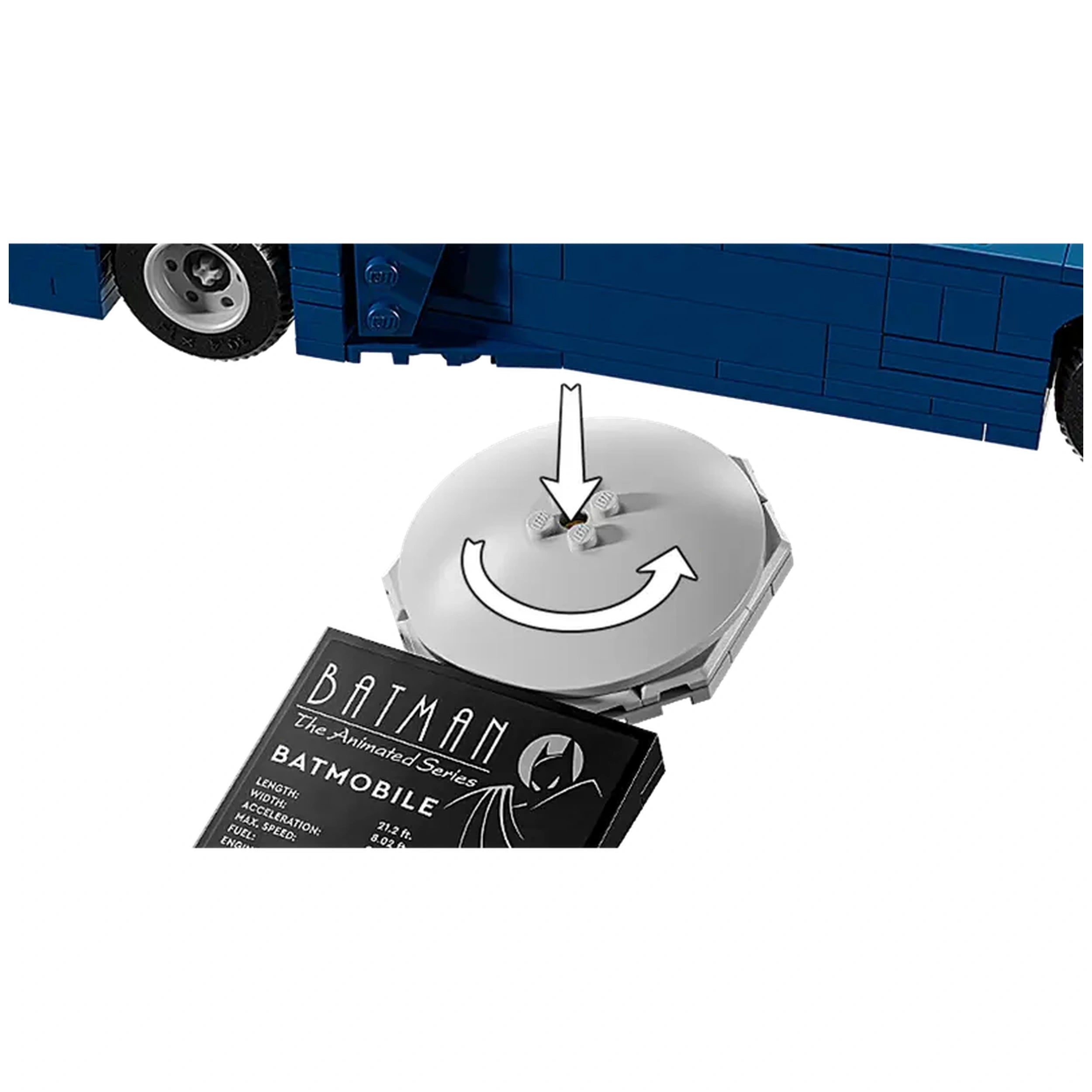 White circular piece with rotating mechanism above a black and white card labeled "Batman - The Animated Series - Batmobile," partially showing a blue toy vehicle's wheel to the side.
