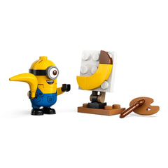 A cheerful Minion character in blue overalls, holding a hand up, stands next to an easel displaying a banana painting, with a paint palette nearby.